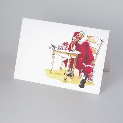 Weihnachtskarte: Weihnachtsmann sitzt am Tisch